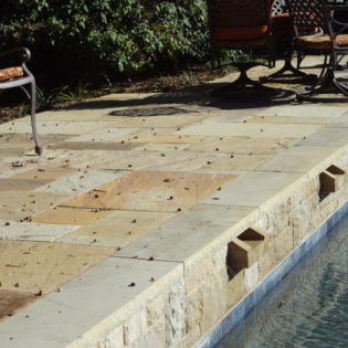 Enhance your patio with beautiful stone pavers and coping, providing durability and style for a perfect outdoor space to relax and entertain.