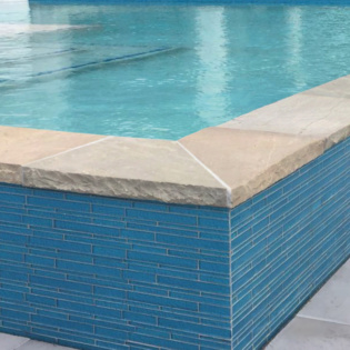 Enhance your pool patio with elegant stone coping and pavers, creating a stylish and safe space for family and friends to enjoy sunny days together.