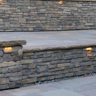 Elevate your stone patio with stylish pier caps and coping featuring a chiseled finish, adding durability and a rugged elegance to your outdoor space.