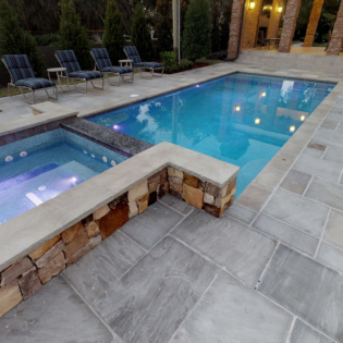 Enhance your backyard with beautiful chiseled natural stone pool coping, creating an elegant and inviting space for relaxation and fun.