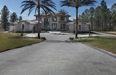 A beautifully designed driveway made of natural stone pavers, showcasing a seamless blend of elegance and durability.